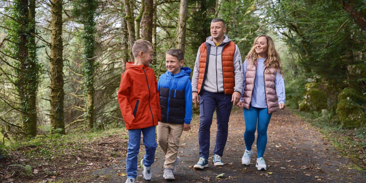 family of four walking through the woods